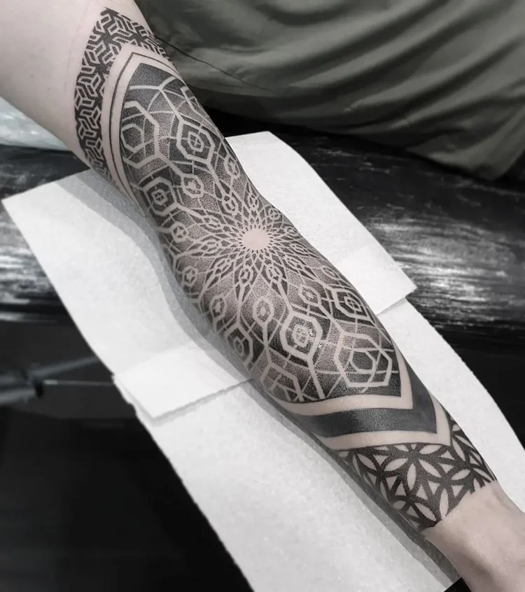 Geometric dotwork mandala forearm tattoo