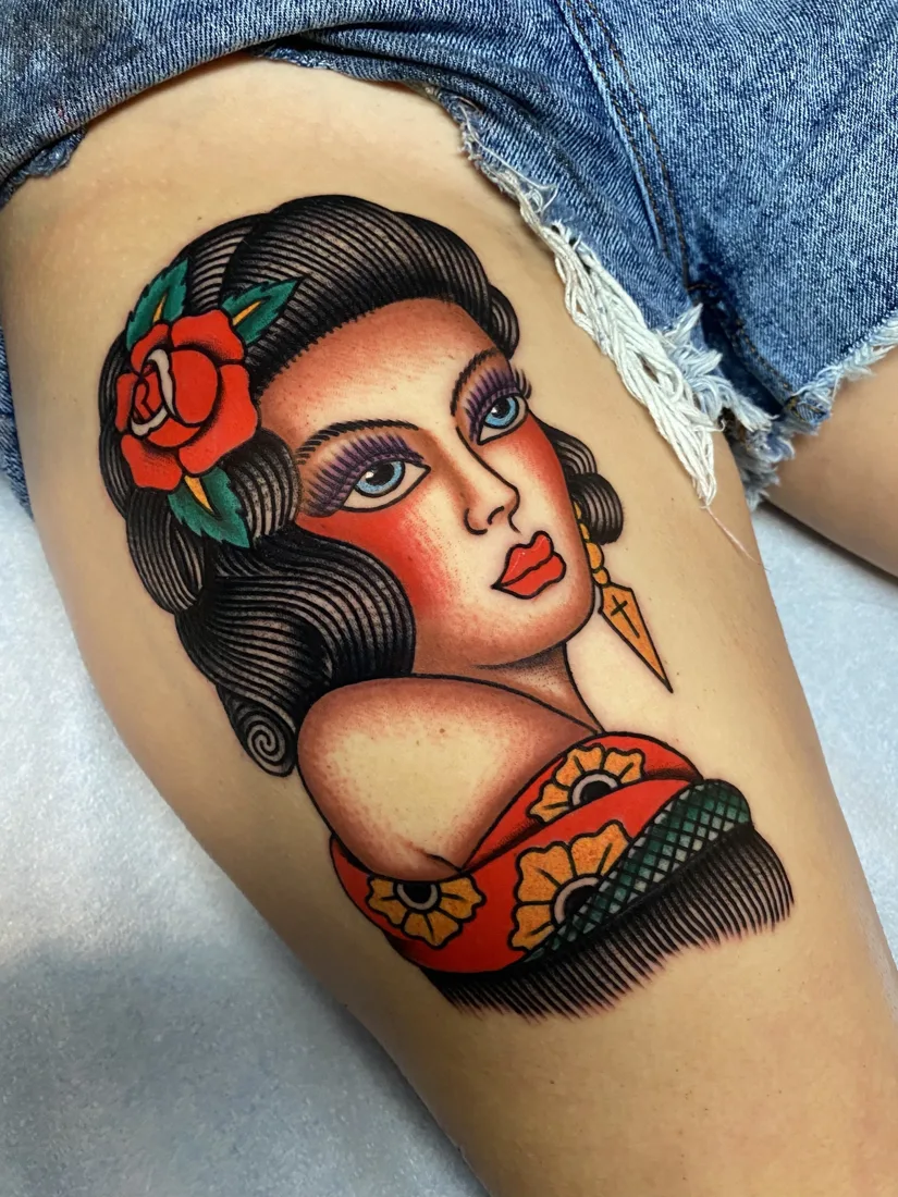 Bold color lady head tattoo on a thigh