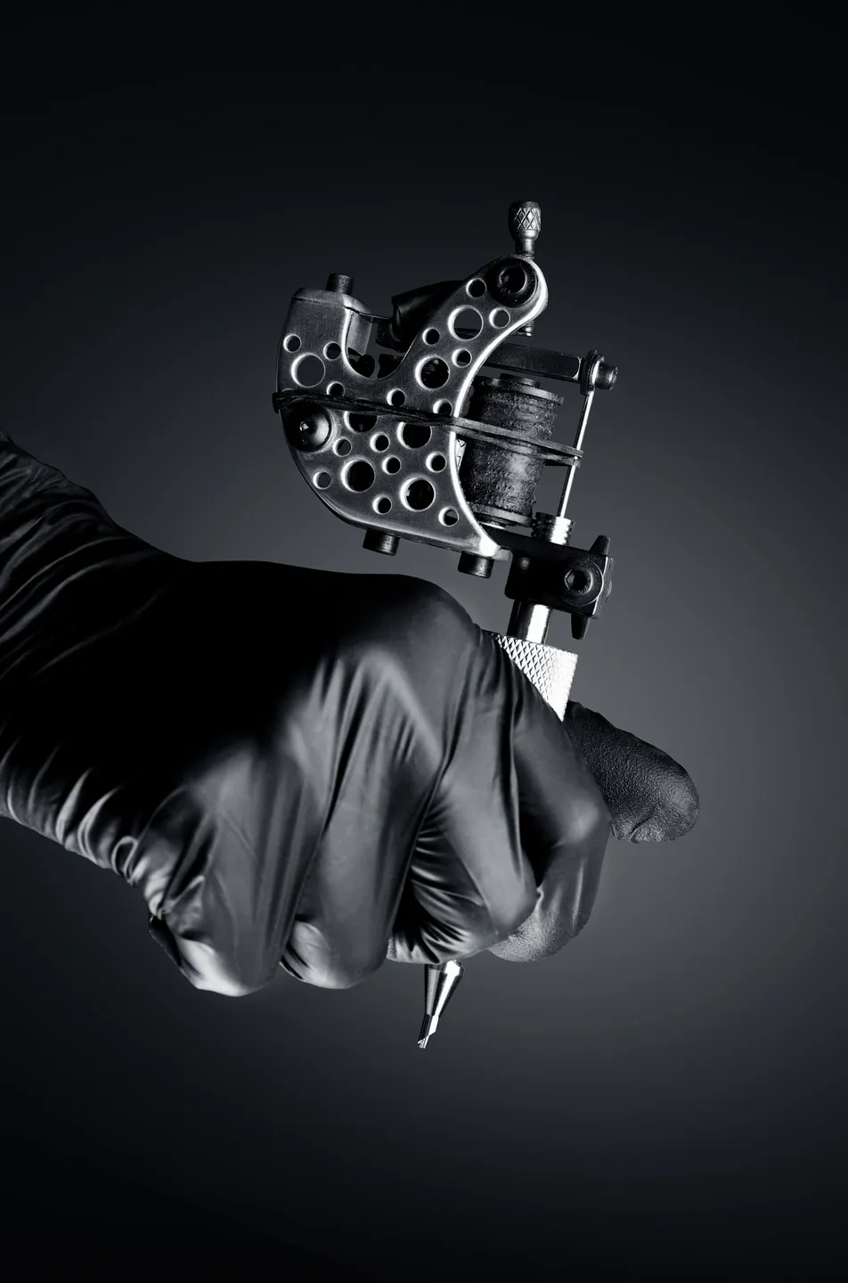 Tattoo machine in a gloved hand